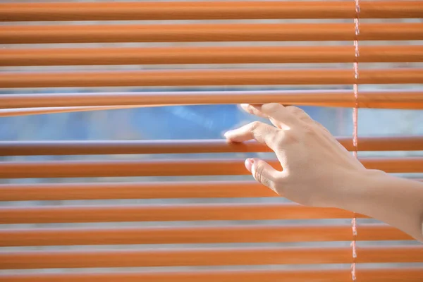 A nő kinyitja a redőnyt az ablakon — Stock Fotó