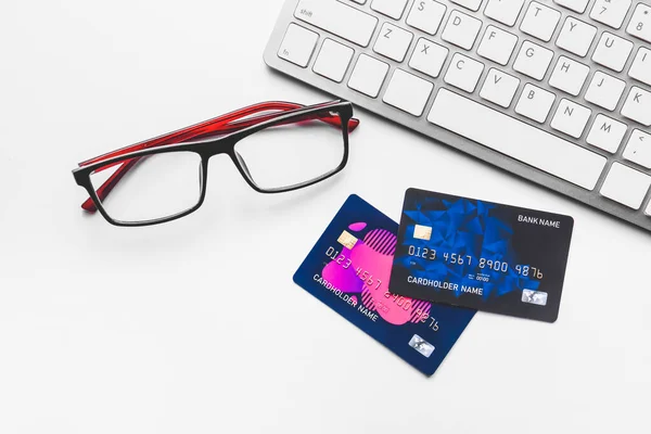 Credit cards with computer keyboard and eyeglasses on white background — Stock Photo, Image