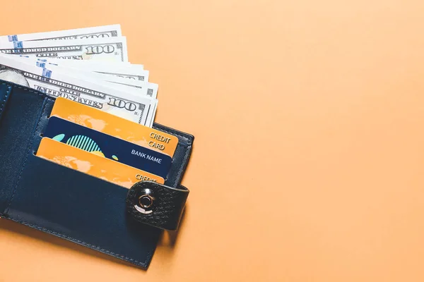 Carteira com cartões de crédito e dinheiro em fundo de cor — Fotografia de Stock