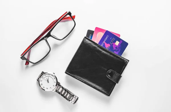 Wallet with credit cards, clock and eyeglasses on white background — Stock Photo, Image