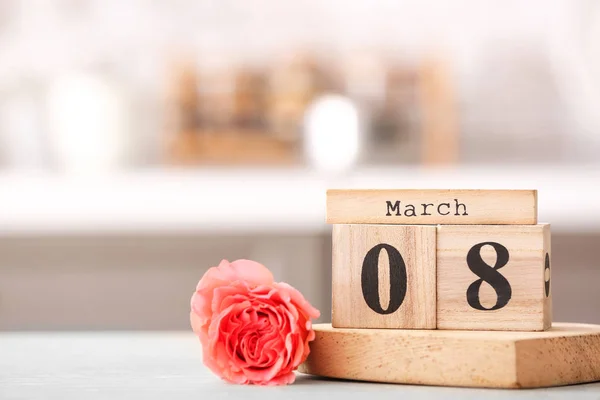 Calendar with date of International Women's Day and flower on table in kitchen — Stock Photo, Image