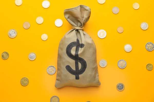 Bag with money and coins on color background — Stock Photo, Image