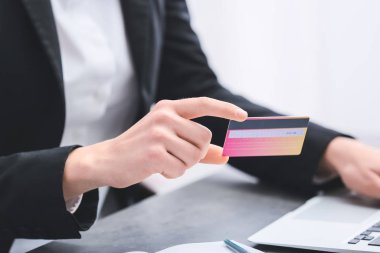 Dizüstü bilgisayar ve kredi kartı masada, closeup kadın ile