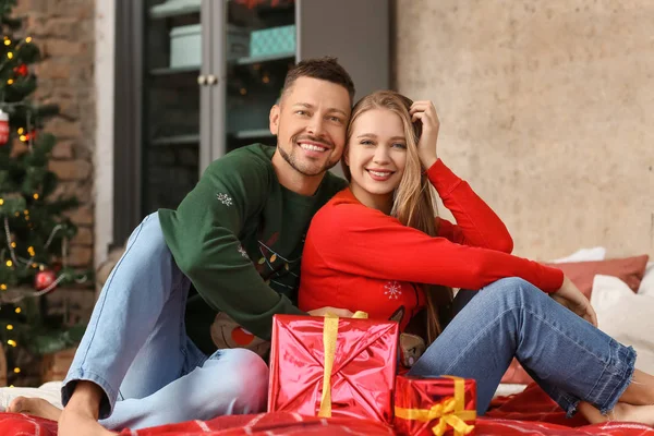 Happy couple with Christmas gifts at home — Stock Photo, Image