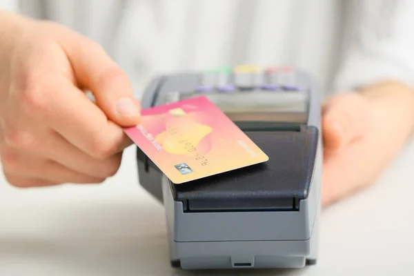 Жінка використовує банківський термінал для оплати кредитною карткою, крупним планом — стокове фото