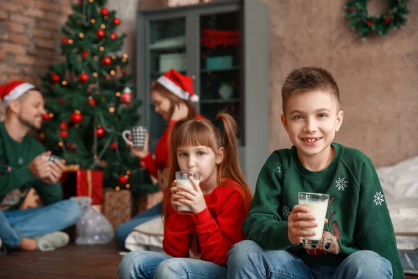 Crianças felizes bebendo leite na véspera de Natal em casa — Fotografia de Stock