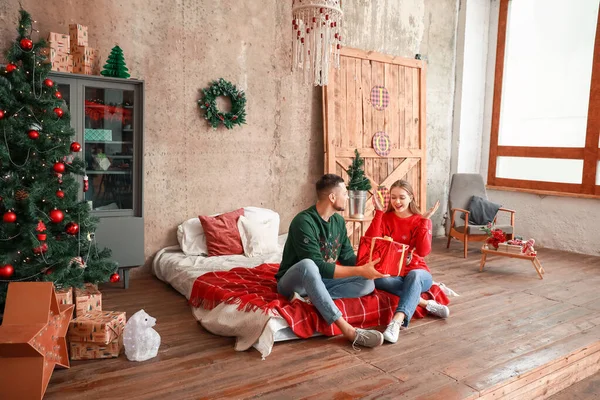 Feliz marido cumprimentando sua esposa no Natal em casa — Fotografia de Stock