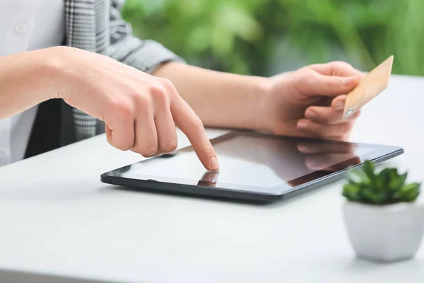 Kobieta z tabletem i kartą kredytową przy stole, zbliżenie — Zdjęcie stockowe