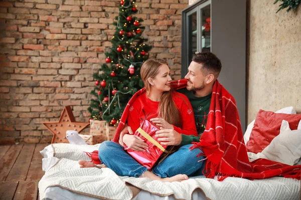 Casal feliz com presente de Natal em casa — Fotografia de Stock