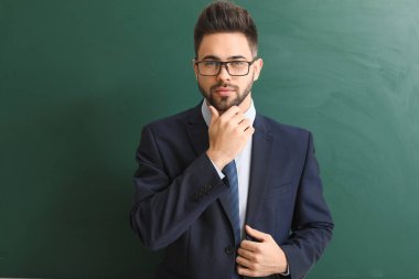 Sınıfta tahtaya yakın erkek öğretmen.