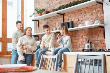 Mutlu aile mutfakta birlikte dinleniyor.