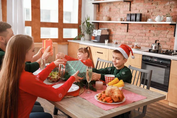 Pais cumprimentando seus filhos no Natal durante o jantar — Fotografia de Stock