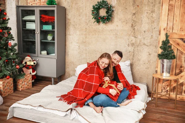 Casal feliz com presente de Natal em casa — Fotografia de Stock