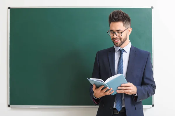 Männlicher Lehrer in der Nähe der Tafel im Klassenzimmer — Stockfoto
