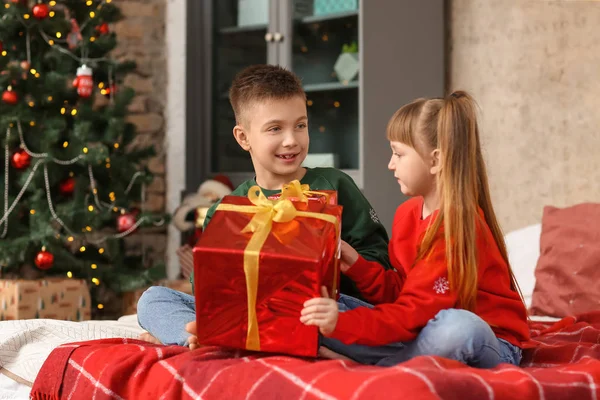 Malé děti s vánočním dárkem doma — Stock fotografie