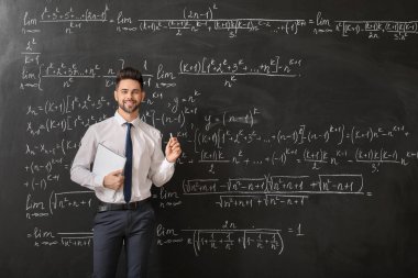 Sınıfta tahtaya yakın erkek öğretmen.