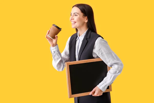 Female teacher with chalkboard and coffee on color background — Stock Photo, Image