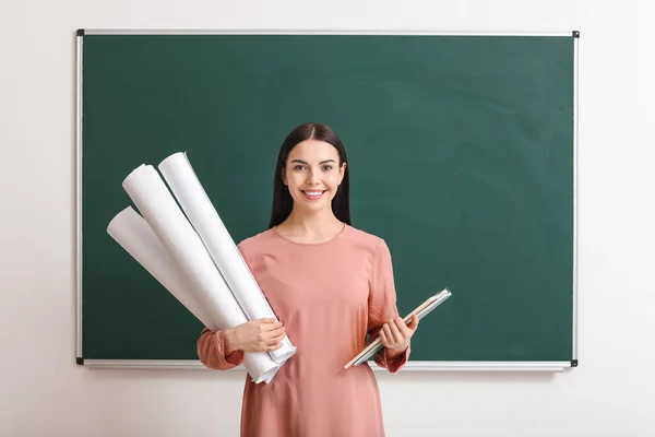 Vrouwelijke leraar in de buurt van schoolbord in de klas — Stockfoto