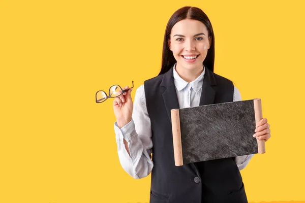 Female teacher with chalkboard on color background — Stock Photo, Image