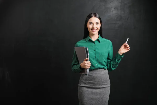 Kvinnlig lärare nära svarta tavlan i klassrummet — Stockfoto