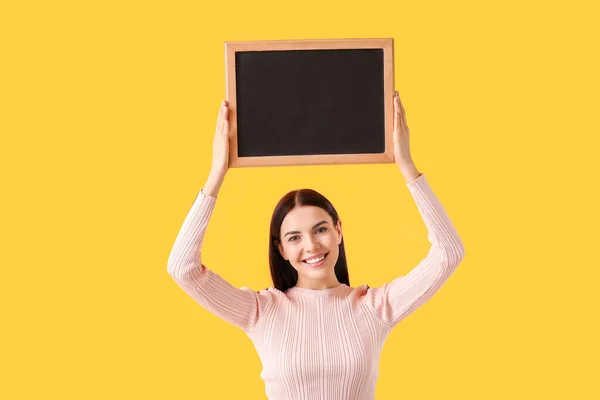 Young woman with chalkboard on color background — Stock Photo, Image
