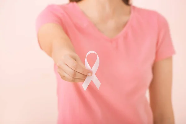 年轻的女人带着粉红色的丝带在彩色背景，特写。 癌症意识概念 — 图库照片