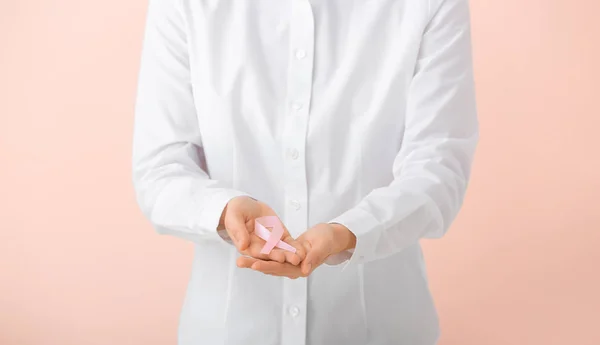 Mujer joven con cinta rosa sobre fondo de color, primer plano. Concepto de concienciación —  Fotos de Stock