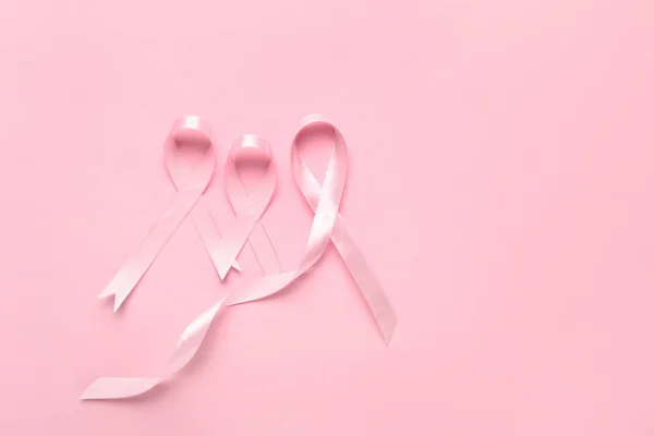 Cintas rosadas sobre fondo de color. Concepto de conciencia sobre el cáncer de mama — Foto de Stock