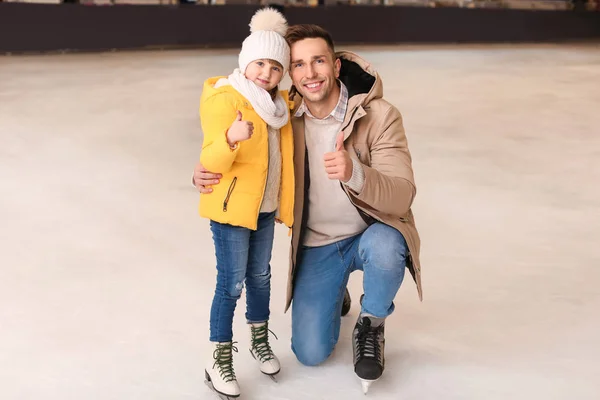 若いですお父さんとともに小さな娘ショー親指アップジェスチャーオンスケートリンク — ストック写真