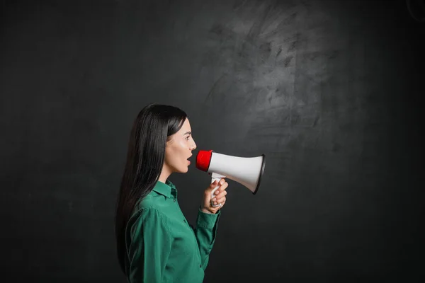 Female teacher with megaphone near blackboard in classroom — Stock Photo, Image