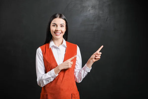 Vrouwelijke leraar in de buurt van schoolbord in de klas — Stockfoto