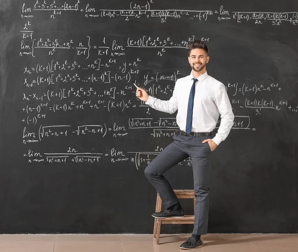 Männlicher Lehrer in der Nähe der Tafel im Klassenzimmer — Stockfoto