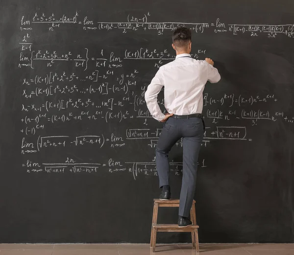 Sınıfta tahtaya yakın erkek öğretmen.