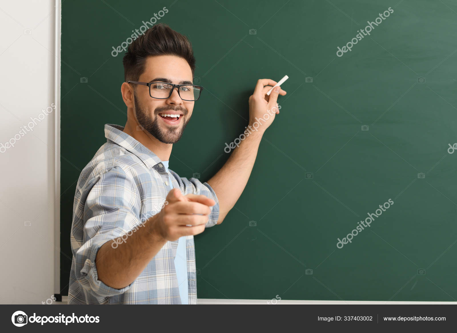 Männlicher Lehrer schreibt auf Tafel im Klassenzimmer - Stockfotografie ...