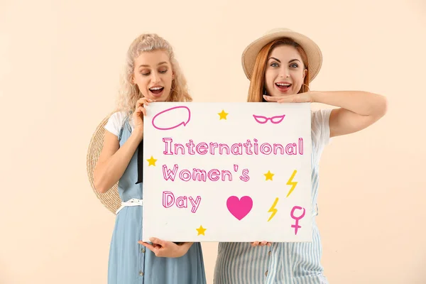 Schöne junge Mädchen halten Poster mit Text zum Internationalen Frauentag auf farbigem Hintergrund — Stockfoto