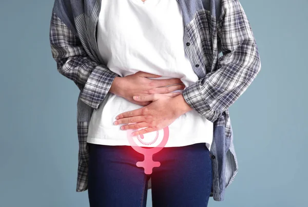 Mulher jovem que sofre de cãibras menstruais no fundo de cor — Fotografia de Stock