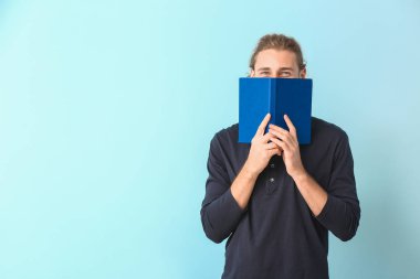 Işıklı arka plan kitabı olan yakışıklı bir adam.