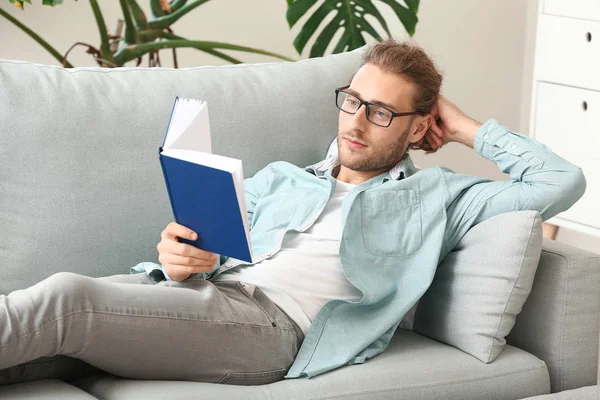 Schöner junger Mann liest Buch zu Hause — Stockfoto