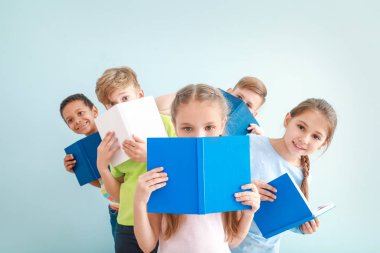 Kitap renk arka plan üzerinde küçük sevimli çocukla