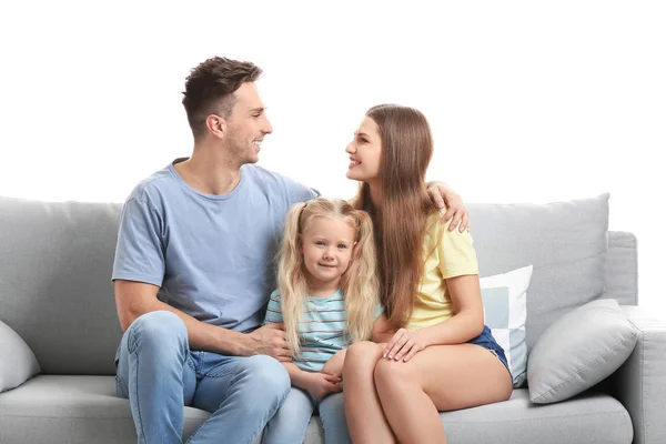 Feliz jovem família sentada no sofá contra fundo branco — Fotografia de Stock