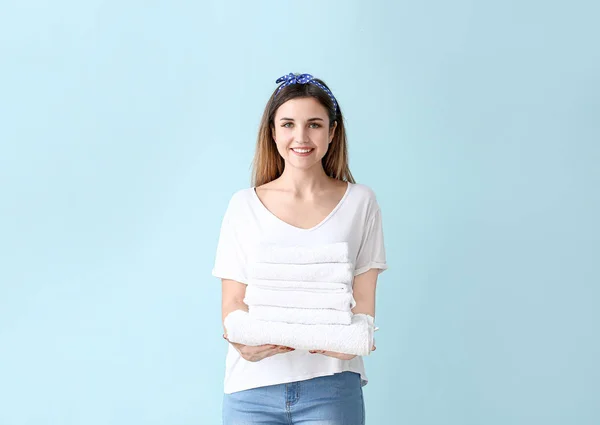 Beautiful young woman with laundry on color background — Stock Photo, Image