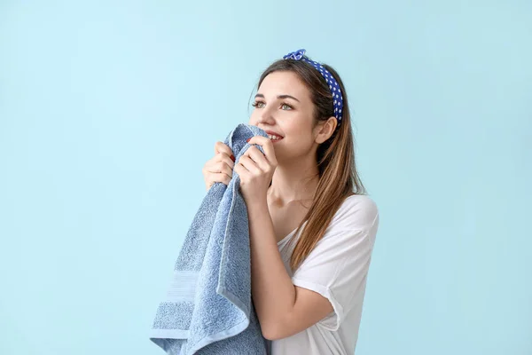 Красива молода жінка з чистим рушником після прання на кольоровому фоні — стокове фото