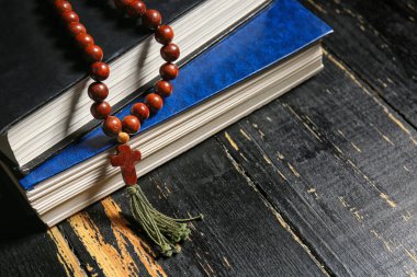 Christian cross and Bibles on dark wooden background