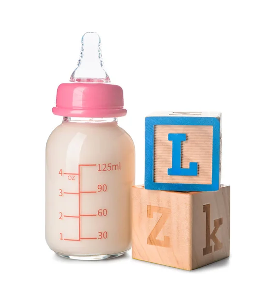 Bottle of milk for baby with cubes on white background — Stock Photo, Image