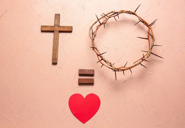 Венок из шипов, крест и сердце на цветном фоне — стоковое фото