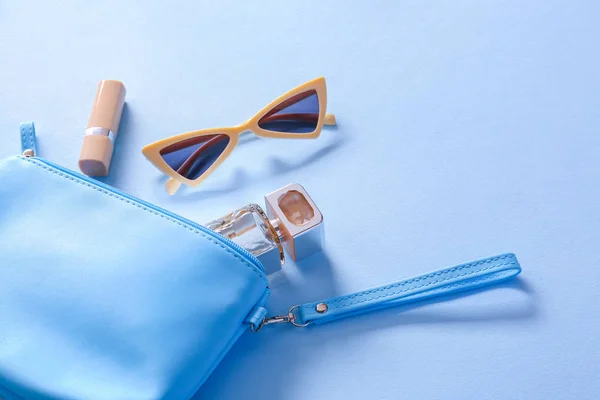Óculos de sol elegantes com saco e cosméticos no fundo de cor — Fotografia de Stock