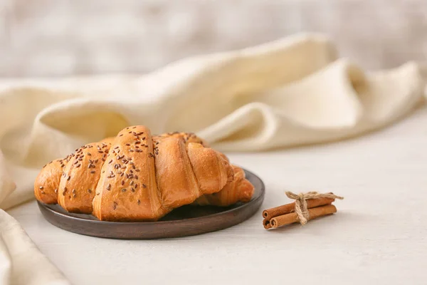 Teller mit leckeren Croissants auf weißem Tisch — Stockfoto