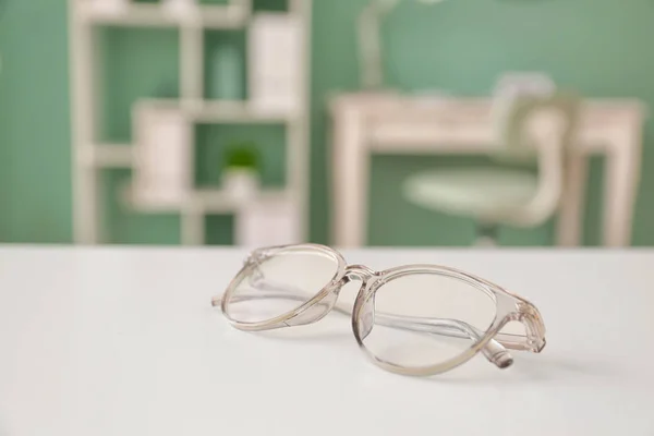 Óculos na mesa na clínica de oftalmologia — Fotografia de Stock