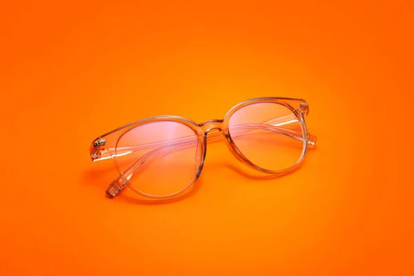 Stylish eyeglasses on color background — Stock Photo, Image