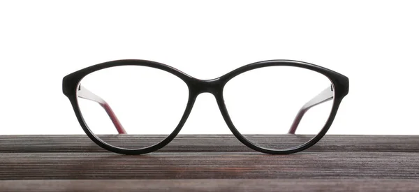 Stílusos szemüveg a fa asztal fehér háttér — Stock Fotó